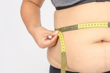 Woman's fingers measuring her belly fat