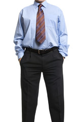 Businessman in blue shirt standing with hands in pockets