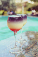 Cocktails on swimming pool background