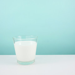 The glass of fresh milk on the white table.