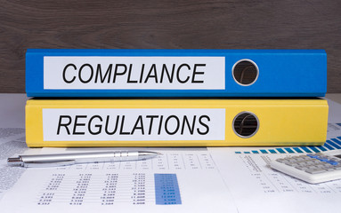 Compliance and Regulations - two binders on desk in the office