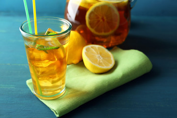 Iced tea with lemon on  color wooden background