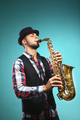 Fototapeta na wymiar Saxophone player on blue background
