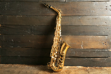 Beautiful golden saxophone on wooden background