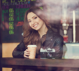 Young woman drinking coffee sitting indoor in urban cafe. Cafe city lifestyle. Casual portrait of teenager girl. Toned