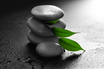 Pile of pebbles with leaf on black background