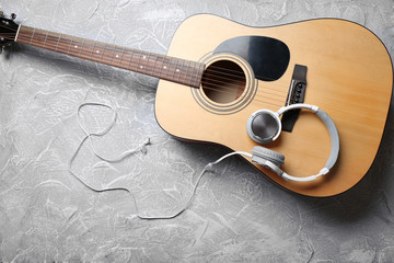 Classical guitar and headphones on grey background