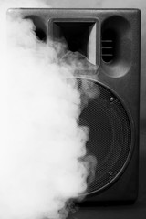 Big loudspeaker in a smoke on black background