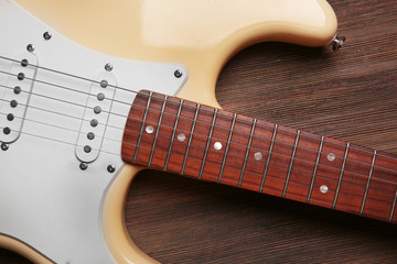 Electric guitar on wooden background, close up