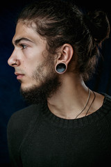 brutal young man with a beard against a dark background