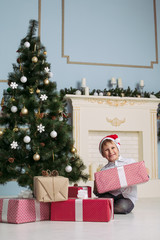 Obraz na płótnie Canvas little boy with gifts near a Christmas tree. new Year.