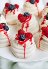 Pavlova meringue cakes decorated with fresh berries