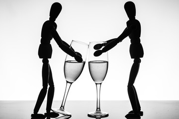 Two wooden puppet with glasses of champagne