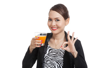 Young Asian woman drink orange juice show OK sign