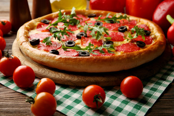 Tasty pizza with salami on decorated wooden table, close up