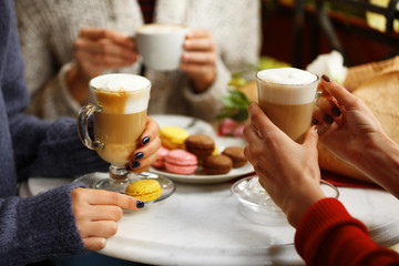 Women meeting in cafe and drinking latte
