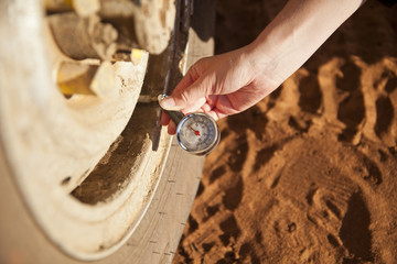 reifendruck prüfen und luft ablassen mit manometer im sand