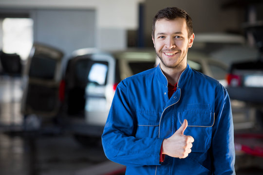 Auto repair service. Handsome smiling mechanic
