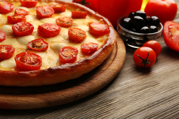 Pizza Margherita with vegetables on wooden table
