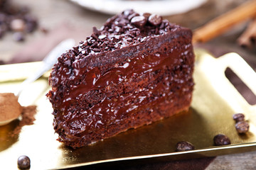 Chocolate cake with chocolate cream on tray, on wooden background
