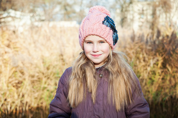 Portrait of the blond young girl at autumn time reed background