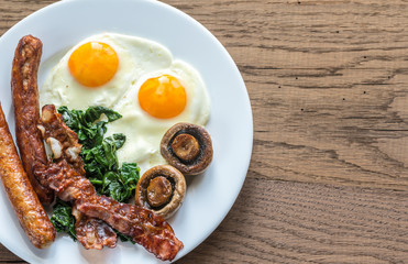 Fried eggs with bacon on the wooden table