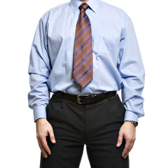 Businessman in blue shirt stands with hands on the hips