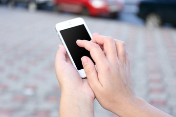 Woman holding smartphone outside