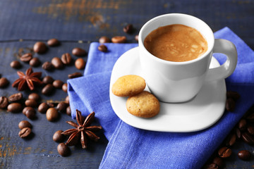 Cup of coffee with spices on wooden table background