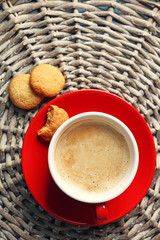 Cup of coffee on wicker mat background
