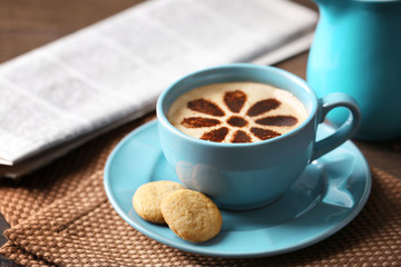 Cup of coffee  and fresh newspaper on wooden table background