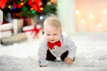 Funny baby  on fluffy carpet on fireplace background