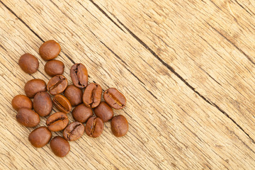 Well roasted coffee beans on old rustic wooden table