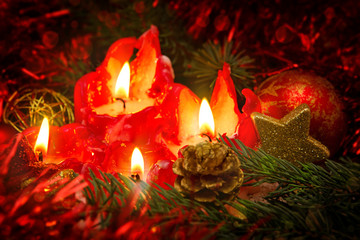Four red candles with christmas ball and decoration.