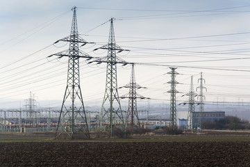 Distribution power station with electricity pylons and dramatic cloudy sky background
