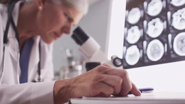 Intelligent female radiologist analyzing with microscope
