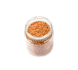 Brown millet grain seed in mason jar over white background