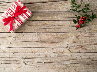Present and Christmas ornament on wooden background