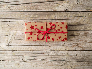 christmas gift with red ribbon on wooden background