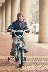 Cute little boy on bike. Vintage toned photo.