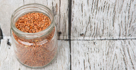 Obraz na płótnie Canvas Brown millet grain seed in a mason jar over wooden background