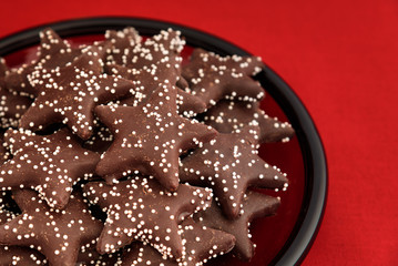 Star shaped chocolate covered cookies on a red plate
