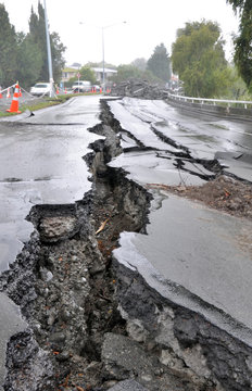 Enormous cracks in a road caused by a devastating earthquake on a rainy day in Christchurch, New Zealand.