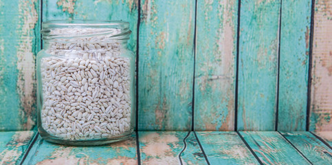 White millet in mason jars over wooden background