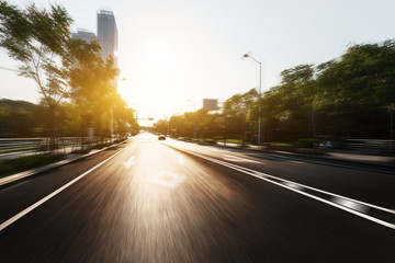 sunlight skyline and road by modern buildings