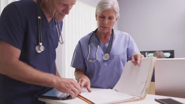 Mature caucasian medical doctors discussing patient file