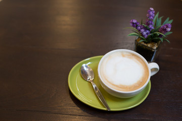 Hot art Latte Coffee in a cup and laptop on wooden table.