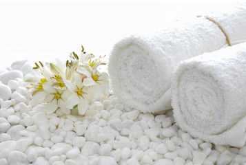 white orchid with towel on  pebbles 