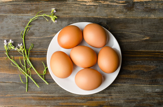 Eggs on white plate and wooden background