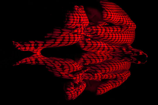 The  body of woman with red pattern and its reflection